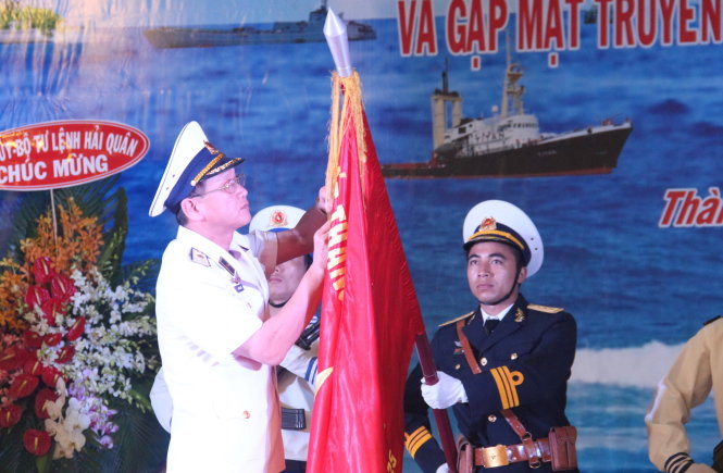 Chuẩn đô đốc Ngô Sỹ Quyết, phó tư lệnh Quân chủng Hải quân, gắn huân chương lên quân kỳ quyết thắng của Lữ đoàn 125 - Ảnh: M.P.