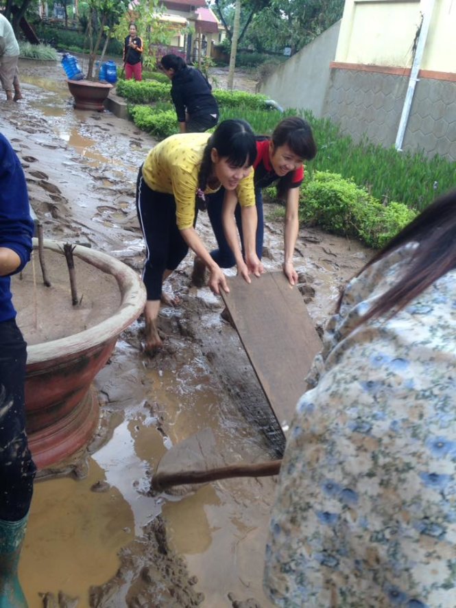 Dọn bùn đất tại Trường Châu Hóa 2, Quảng Bình để đón học sinh - Ảnh: Vĩnh Quý