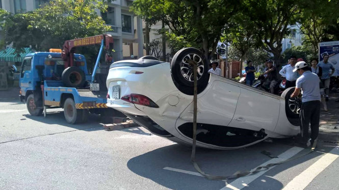 Hiện trường vụ tai nạn, chiếc xe hơi màu trắng bị lật ngửa sau va chạm - Ảnh: LÊ PHAN