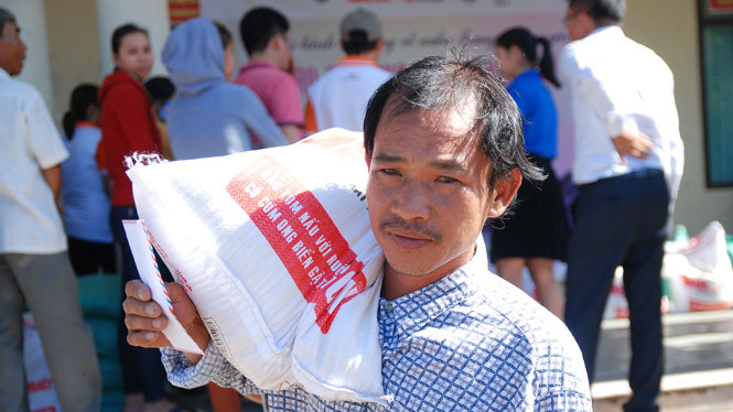 Ông Phan Văn Dụng, trú thôn Tân An, xã Hải An, Hải Lăng đưa phần gạo về nhà trong niềm vui - Ảnh: QUỐC NAM