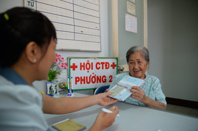 Người dân ở P.2, Q.Phú Nhuận, TP.HCM đến UBND P.2 đăng ký mua bảo hiểm y tế để được hưởng ưu đãi giảm giá khi mua bảo hiểm y tế hộ gia đình - Ảnh: HỮU KHOA