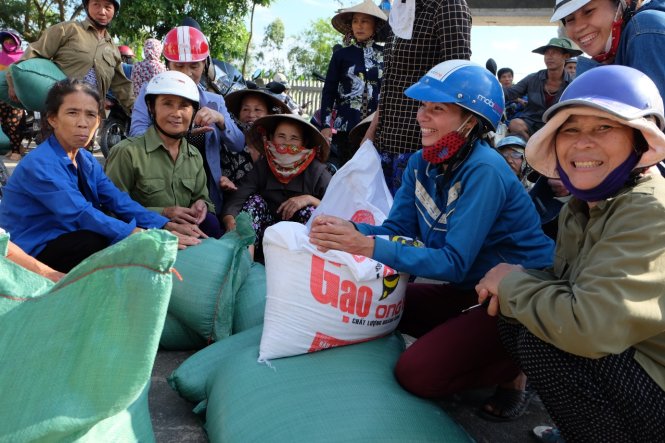 Người dân vùng lũ Quảng Trường rất vui khi được nhận gạo cứu trợ - Ảnh: QUỐC NAM