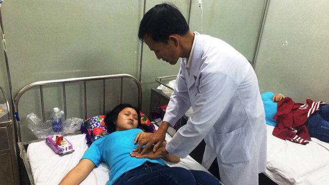 Bác sĩ Bác sĩ Đặng Hồng Tú khám và chăm sóc cho một công nhân bị nhập viện - Ảnh: LÊ PHAN