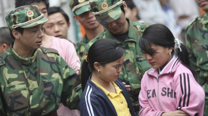 Hai lao động trẻ em gái được giải cứu khỏi một nhà máy ở Dongguan, Trung Quốc - Ảnh: Reuters