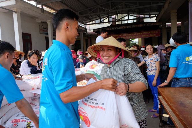 Người dân vùng lũ Quảng Thanh rất vui khi được nhận gạo cứu trợ – Ảnh: QUỐC NAM