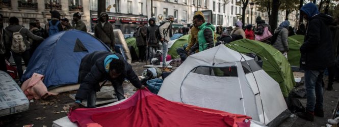 Người di cư Sudan tất bật dựng lều nhỏ trên đại lộ Flandres, ở quận 19 của thủ đô Paris, vào ngày 28-10 - Ảnh: AFP