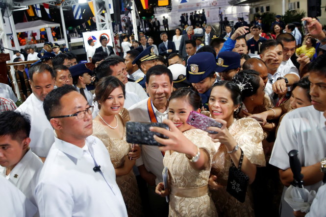 Tổng thống Duterte chụp ảnh selfie với người dân trong một sự kiện tại Manila ngày 12-10 - Ảnh: Reuters