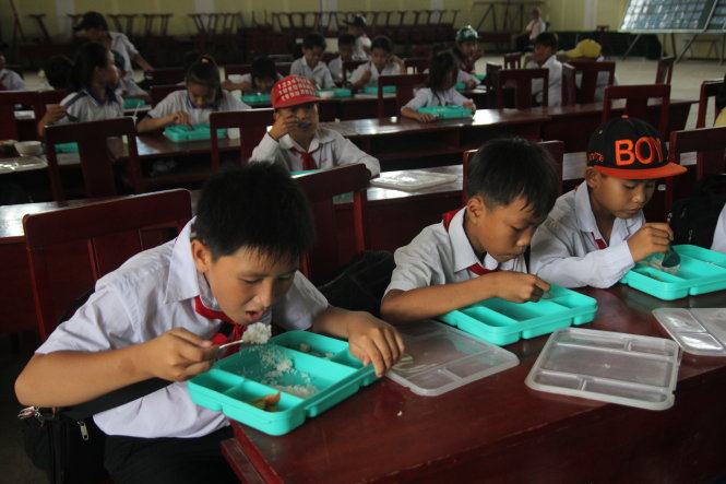 Các học sinh tiểu học Phú Thạnh, huyện Tân Phú Đông, Tiền Giang ăn suất cơm trưa miễn phí tại trường - Ảnh: MẬU TRƯỜNG