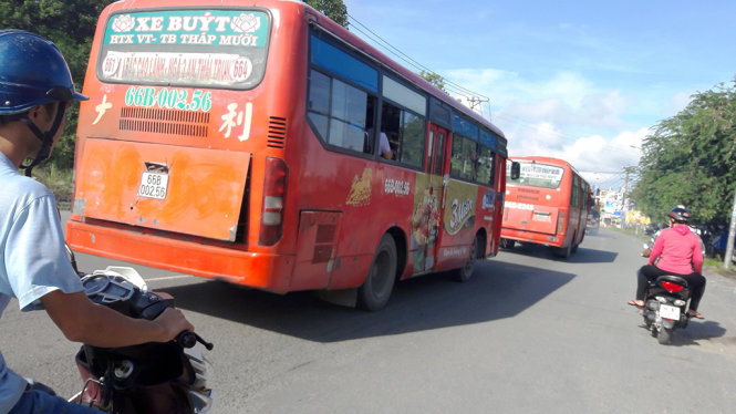 Hai xe buýt của cùng 1 HTX chạy so kè với nhau để tranh giành tuyến - Ảnh: NGỌC TÀI