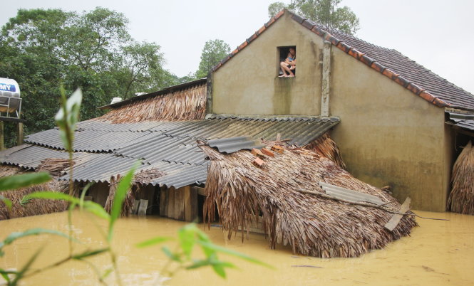 Một gia đình ở xã Phương Mỹ, huyện Hương Khê (Hà Tĩnh) phải di dời lên nóc nhà khi nước lũ lên  - Ảnh: DOÃN HÒA