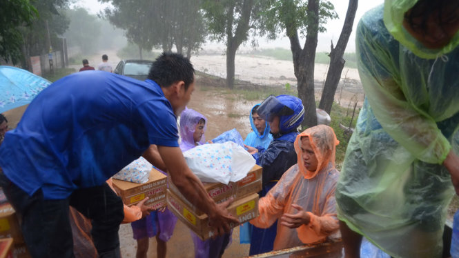 Quà cứu trợ khẩn cấp được trao tận tay bà con thôn Bắc Bình trong mưa lớn   - Ảnh: TẤN LỰC