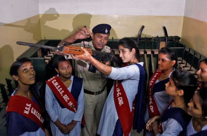 A police officer shows the functions of a gun to schoolgirls during their visit inside a police station as part of the 50th Raising Day celebrations of Chandigarh Police in Chandigarh, India, November 2