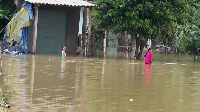 Hai em nhỏ tại xã Quảng Liên (Quảng Trạch) vô từ chơi đùa trong nước lũ – Ảnh: QUỐC NAM