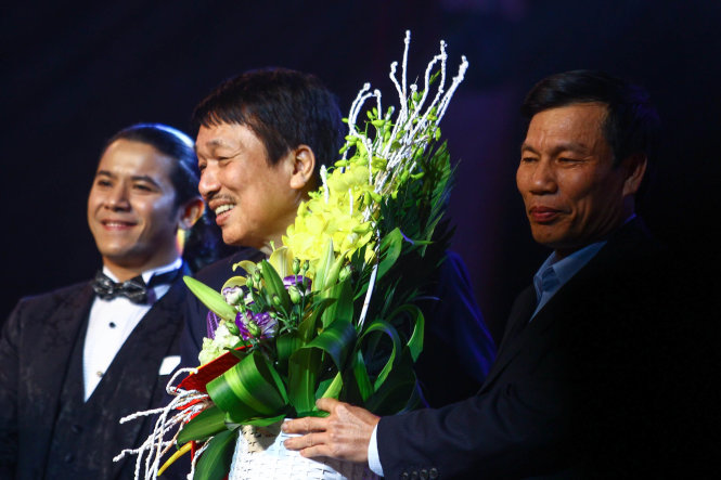 Bộ trưởng Bộ VHTT&DL Nguyễn Ngọc Thiện tặng hoa chúc mừng nhạc sĩ Phú Quang sau khi đêm diễn kết thúc - Ảnh: NGUYỄN KHÁNH