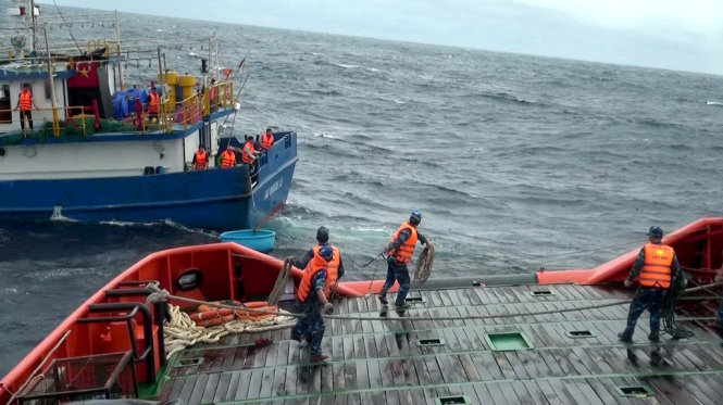 Cán bộ, chiến sỹ tàu Cảnh sát biển 9001 đang làm dây để đưa tám ngư dân tàu cá BĐ 99939 sang tàu mình- Ảnh: Đ. ĐỊNH