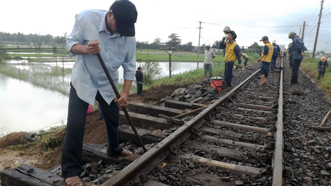 Công nhân đang gia cố taluy âm đường sắt đoạn qua xã Bình Ngọc- Ảnh: KIM THỦY