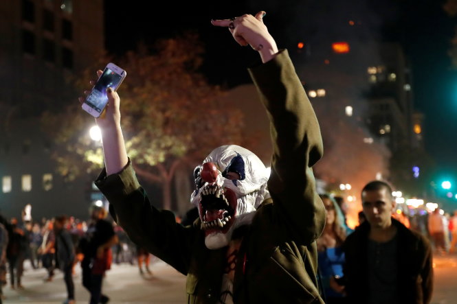 Người biểu tình chống ông Trump biểu thị phản ứng với cảnh sát tại Oakland, bang California tối 9-11 - Ảnh: Reuters