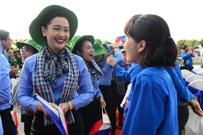 Đại biểu nước Philippines vui vẻ nhận nón tai bèo và khăn rằn do các thanh niên Việt Nam trao tặng - Ảnh: QUANG ĐỊNH