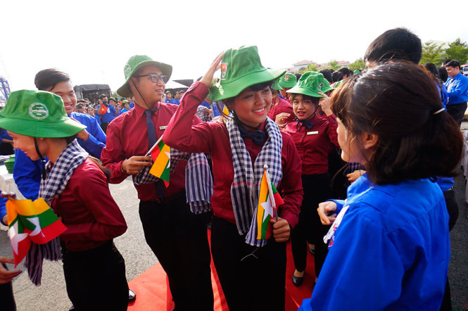 Đại biểu nước Myanmar vui vẻ nhận nón tai bèo và khăn rằn do các thanh niên Việt Nam trao tặng - Ảnh: QUANG ĐỊNH