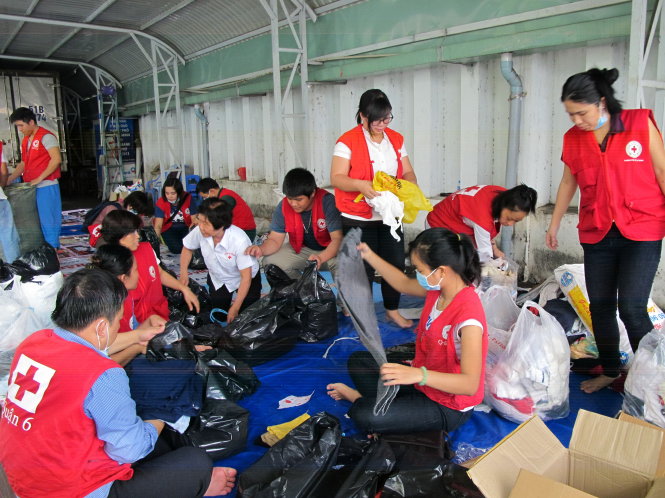 Các tình nguyện viên phân loại quần áo cũ - Ảnh: K.ANH
