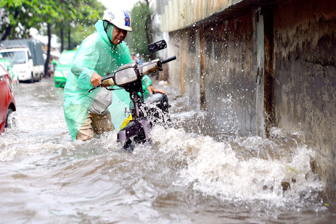 TP.HCM thường xuyên bị ngập khi mưa lớn gây xáo trộn cho cuộc sống của người dân. Trong ảnh: cảnh ngập nước trên đường Nguyễn Hữu Cảnh, P.22, Q.Bình Thạnh - Ảnh: HỮU KHOA