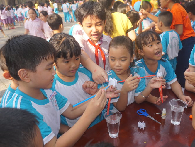 Học sinh Trường Nguyễn Thái Học xúm xít làm máy bơm nước bằng sức gió - Ảnh: H.Hương
