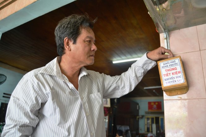 Người dân khối phố Bình Phước (thị trấn Tiên Kỳ, huyện Tiên Phước) bỏ tiền vào thùng tiết kiệm gây quỹ khuyến học - Ảnh: LÊ TRUNG
