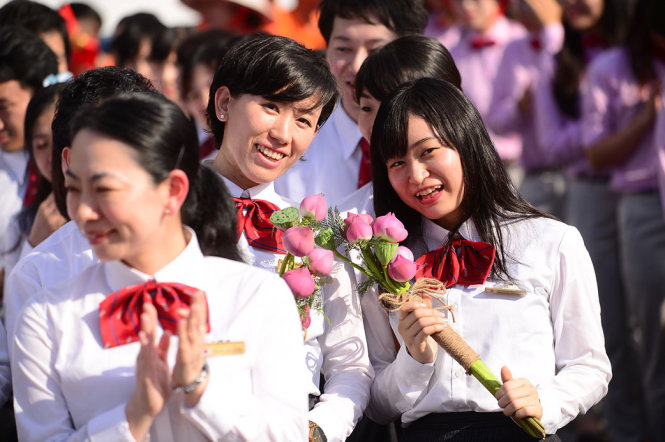 Đại biểu Nhật Bản xinh tươi cùng hoa sen do thanh niên VN trao tặng - Ảnh: QUANG ĐỊNH