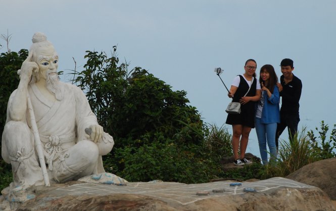 Du khách chụp ảnh trên đỉnh Sơn Trà ở điểm bàn cờ Tiên ông - Ảnh: V . Hùng