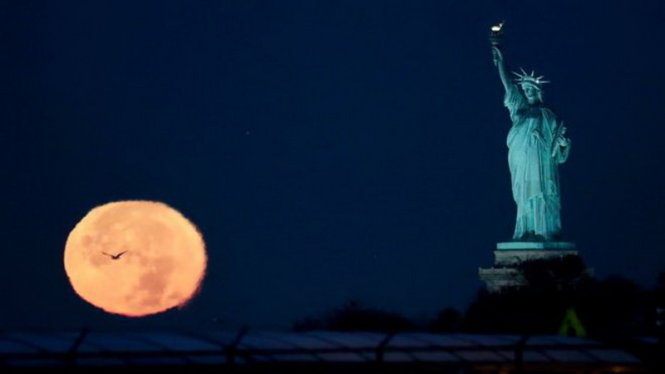 Siêu trăng xuất hiện gần Tượng Nữ thần Tự do ở New York, Mỹ - Ảnh: AFP