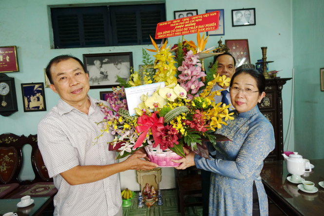 Bà Võ Thị Dung, phó bí thư Thành ủy TP.HCM, tặng hoa chúc mừng Ngày nhà giáo VN cho đại diện gia đình cố GS Trần Đại Nghĩa - Ảnh: NHƯ HÙNG
