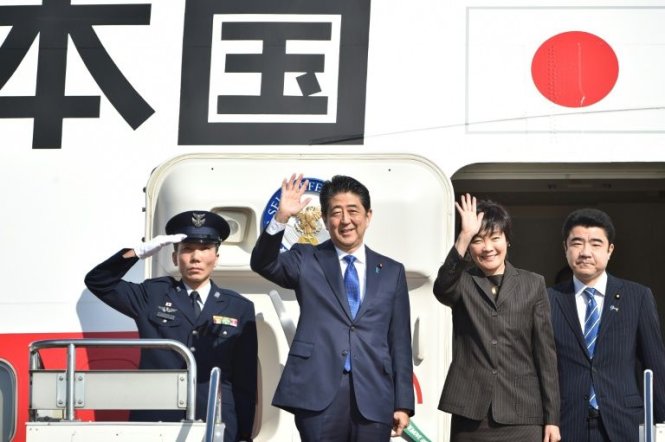 Thủ tướng Nhật Bản Shinzo Abe và phu nhân Akie vẫy tay chào mọi người trước khi lên máy bay tại sân bay Haneda ở Tokyo ngày 17-11 - Ảnh: AFP