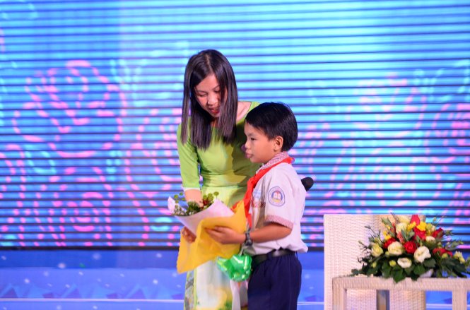 Em Nguyễn Duy Anh - người được cô giúp đỡ vượt qua khó khăn xúc động tặng cô bó hoa trong ngày tuyên dương - Ảnh: Hữu Khoa