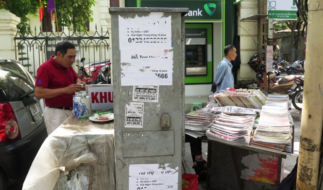 Tận dụng “bom nổ chậm” để làm nơi kinh doanh trà đá, sạp báo trên phố Phan Đình Phùng - Ảnh: Quang Thế