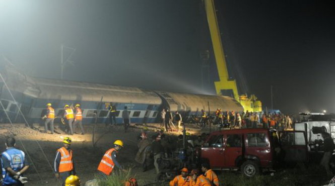 Nhân viên cứu hộ tìm kiếm người sống sót trong vụ lật tàu lửa - Ảnh: AFP