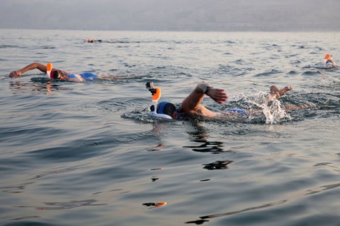 Nhiều người mang mặt nạ để bảo vệ mắt và miệng khi bơi trên biển Chết - Ảnh: AFP