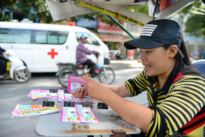 Chị Trần Thị Tuyết Nhanh (Bình Định) bán vé số kiến thiết tại TP.HCM cho biết từ khi có vé số Vietlott, lượng vé bán được giảm một nửa, còn dưới 100 tờ/ngày - Ảnh: Hữu Khoa