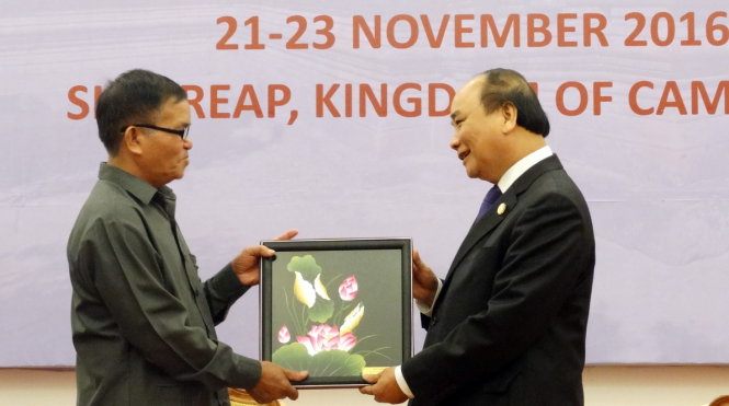 Thủ tướng Nguyễn Xuân Phúc tặng quà lưu niệm cho đại diện Việt kiều tại Siem Riep - Ảnh: K.HƯNG