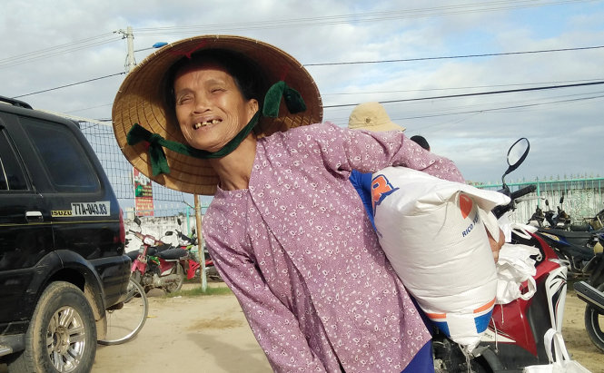 của người dân vùng lũ Ân Nghĩa (huyện Hoài Ân, tỉnh Bình Định) khi nhận quà cứu trợ của Tuổi Trẻ - Ảnh: Trường An