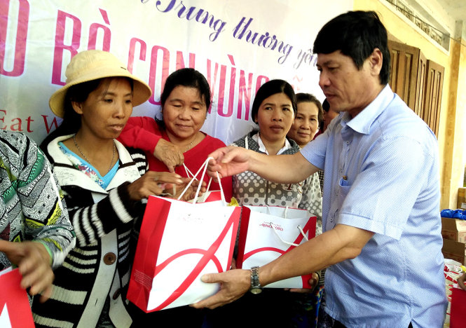 Ông Bùi Văn Thành – chủ tịch UBND huyện Tuy An – trao quà cứu trợ của Tuổi Trẻ cho người dân xã An Nghiệp - Ảnh: TRƯỜNG AN