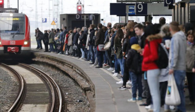 Hàng người dài xếp hàng chờ xe lửa tại Đức - Ảnh: AP