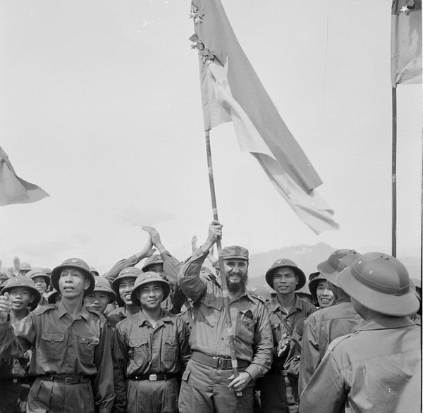 Lãnh tụ Fidel Castro phất cao lá cờ bách chiến, bách thắng lấp lánh huân chương của đoàn Khe Sanh, quân Giải phóng Huế - Ảnh: TTXVN