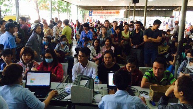 Nhiều người dân chen lấn, xếp hàng trước quầy vé để đợi bốc số mua vé - Ảnh: THU DUNG