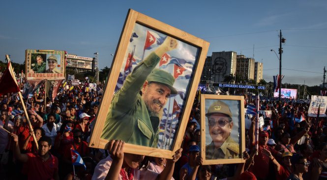 Người dân Cuba giương cao ảnh lãnh tụ Fidel Castro và Chủ tịch Raul Castro trong cuộc diễu hành kỷ niệm ngày 1-5-2016 tại Havana - Ảnh: AFP