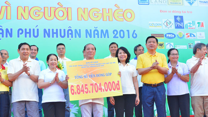 Ông Đinh La Thăng và bà Võ Thị Dung chúc mừng ban tổ chức sau khi công bố tổng số tiền đã được gây quỹ - Ảnh: LĨNH HỒNG
