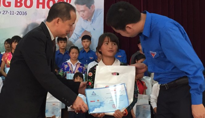 Ông Lê Xuân Trung phó TBT báo Tuổi Trẻ (bìa trái) và ông Lò Văn Đức phó bí thư tỉnh đòan Điện Biên trao học bổng cho các em học sinh - Ảnh: Thân Hoàng.