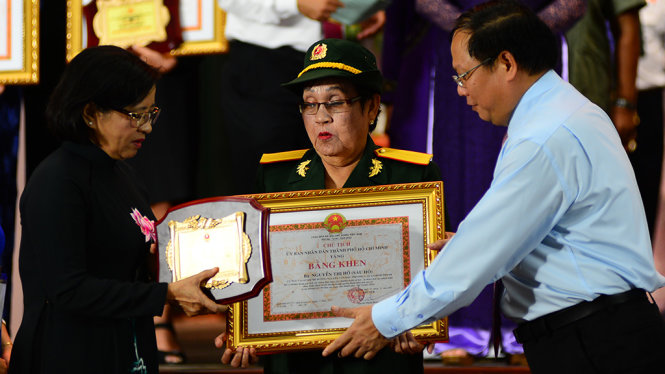 Phó bí thư thường trực Thành ủy TP.HCM Tất Thành Cang (phải) và Trưởng Ban tuyên giáo Thành ủy TP.HCM Thân Thị Thư trao tặng bằng khen cho bà Nguyễn Thị Hộ sáng 26-11 - 
Ảnh: QUANG ĐỊNH