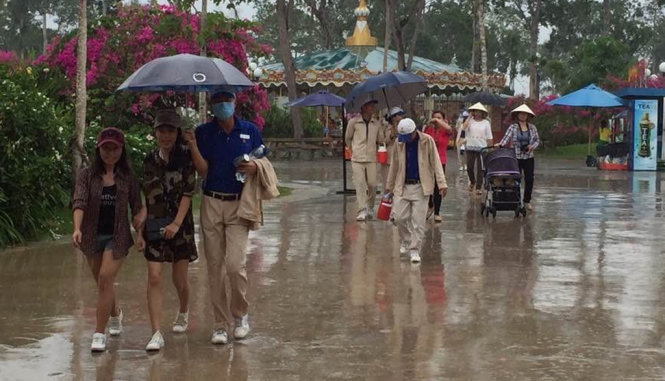 Du khách đi chơi lễ dưới trời mưa - Ảnh: Hoàng Trung