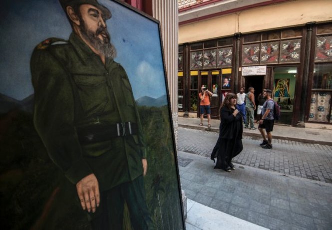 Người dân ở Havana đang đi gần bức họa chân dung lãnh tụ cách mạng Fidel Castro - Ảnh: AFP