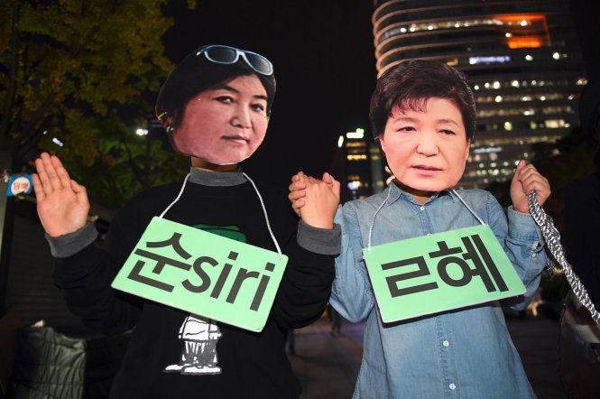 Người biểu tình đeo mặt nạ có hình bà Park Geun-hye (phải) và bạn gái của bà, Choi Soon-sil trong cuộc biểu tình ngày 27-10 tại Seoul - Ảnh: AFP